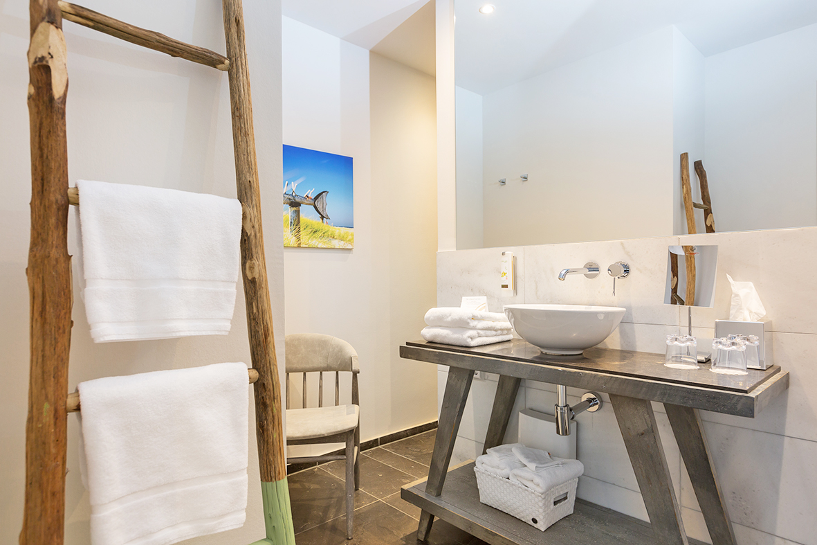 Easy Living Doppelzimmer weißer Waschbecken mit Handtuchhalter im Vordergrund